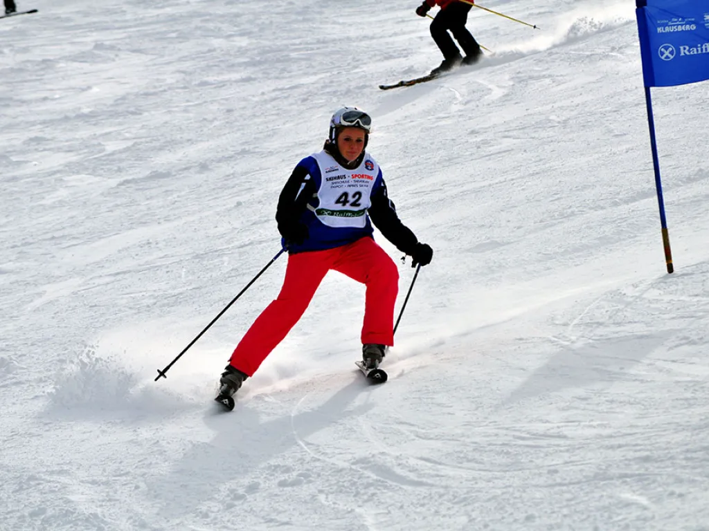 Skifahrer mit Startnummer 42 in roter Hose auf der Strecke.